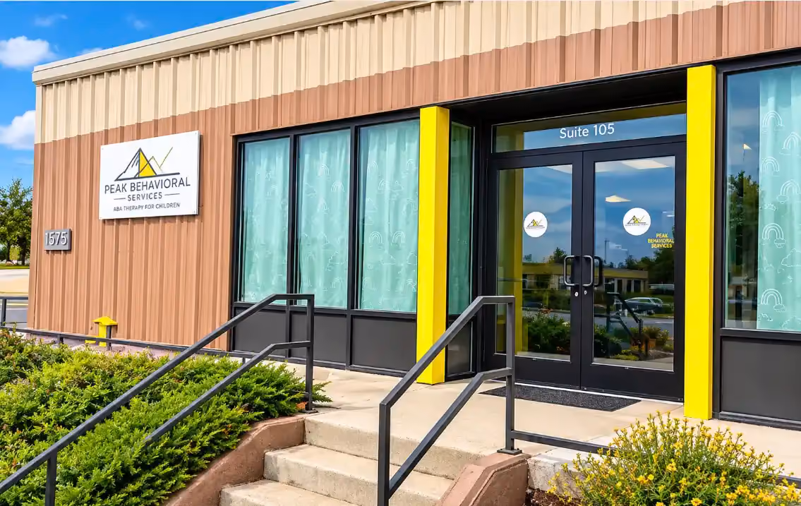 Glass entrance of Peak Behavioral Services in Laramie, Wyoming, with the Peak logo on the door.